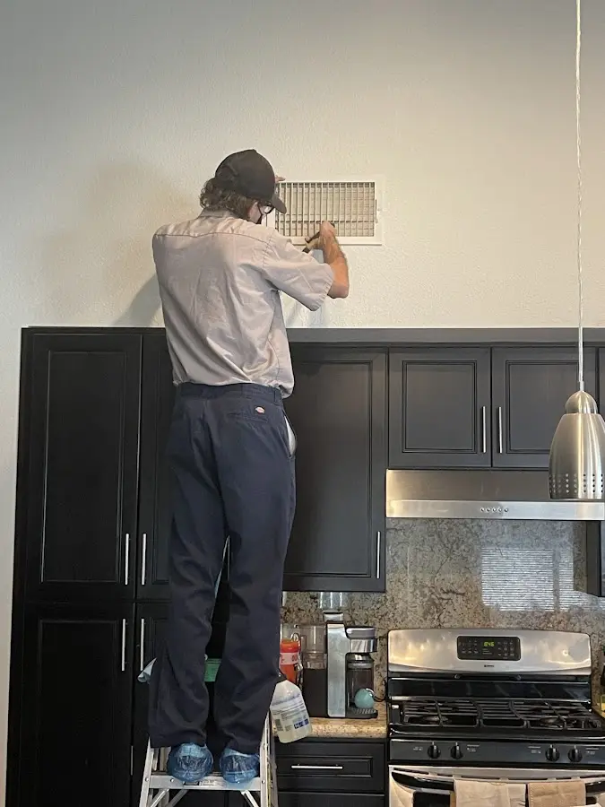 Technician inspecting an air vent during HVAC service in Terrytown